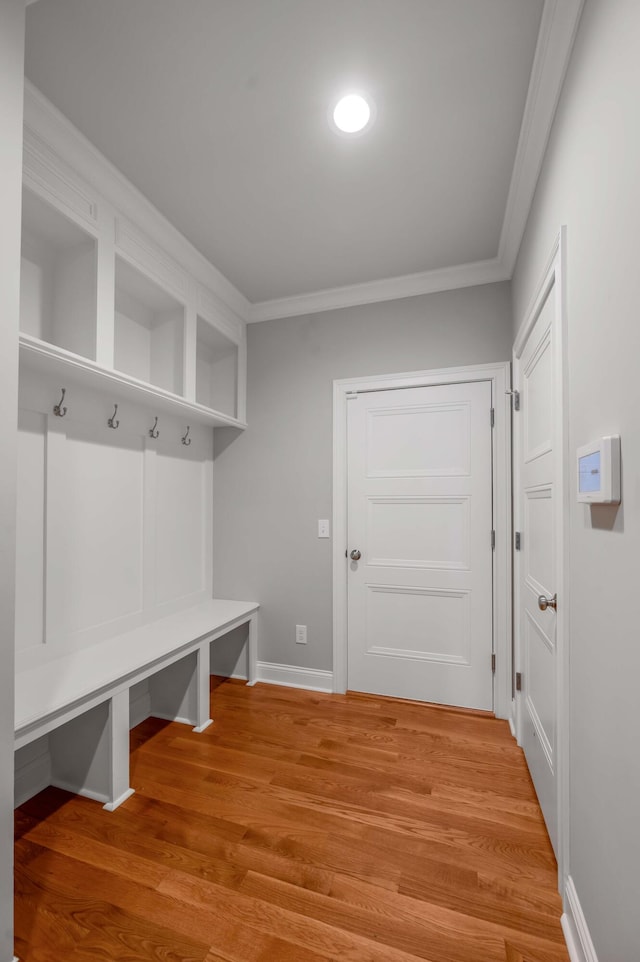 mudroom with baseboards, crown molding, and light wood finished floors