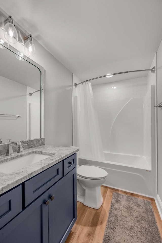 full bathroom with toilet, vanity, shower / tub combo with curtain, and wood finished floors