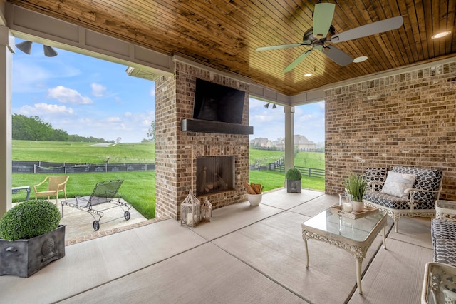 view of patio / terrace with an outdoor living space with a fireplace, a ceiling fan, and fence