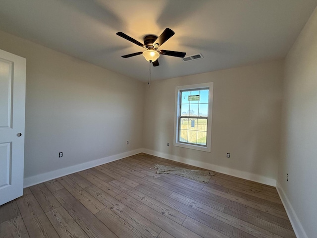 empty room with ceiling fan and light hardwood / wood-style floors