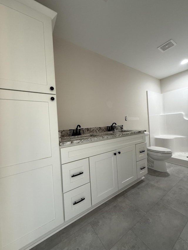 bathroom with vanity, toilet, and walk in shower