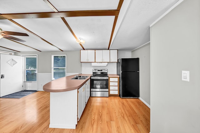 kitchen featuring light hardwood / wood-style flooring, black fridge, stainless steel electric range, and white cabinets