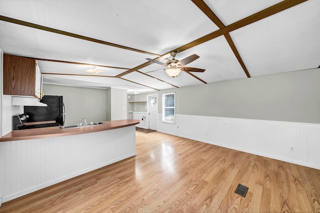 interior space featuring light hardwood / wood-style floors, sink, ceiling fan, and beamed ceiling