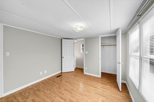 unfurnished bedroom with a textured ceiling and light hardwood / wood-style flooring