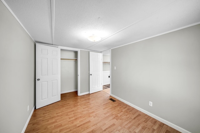 unfurnished bedroom featuring a textured ceiling and light hardwood / wood-style flooring