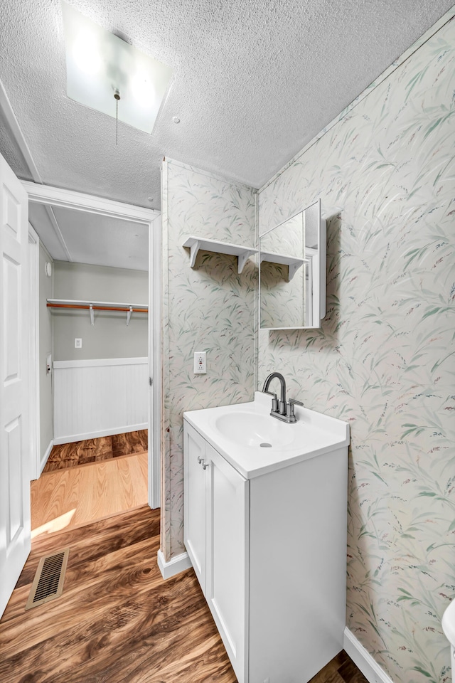 bathroom featuring vanity, hardwood / wood-style floors, and a textured ceiling