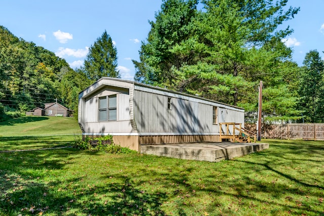 view of home's exterior featuring a wooden deck and a yard