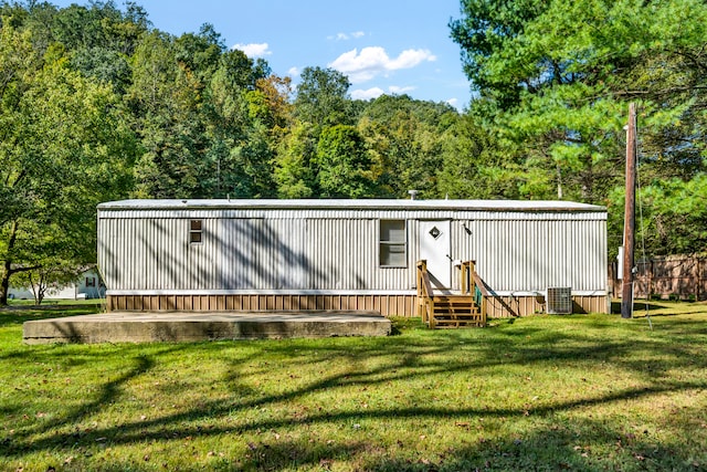 back of house featuring a lawn and central air condition unit