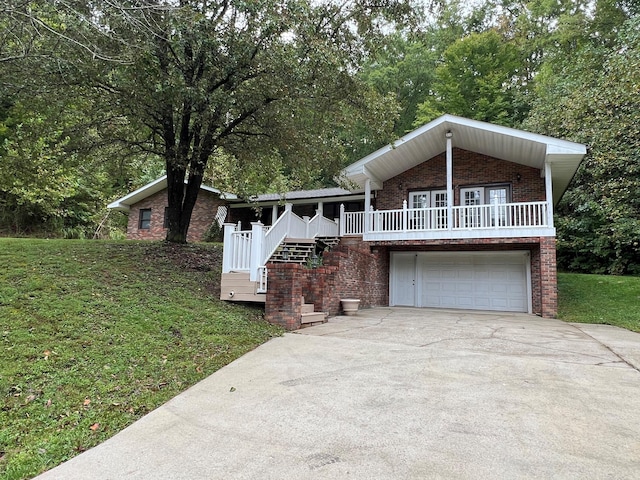 view of front of property with a garage, a front lawn, and covered porch