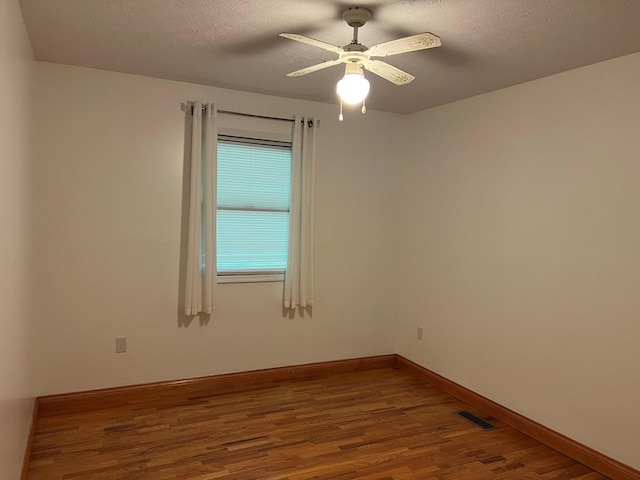 unfurnished room featuring a textured ceiling, ceiling fan, and hardwood / wood-style flooring