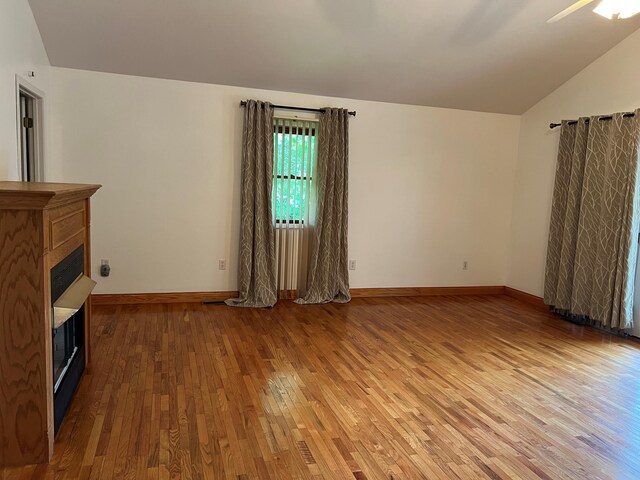 unfurnished living room featuring ceiling fan, hardwood / wood-style flooring, and lofted ceiling