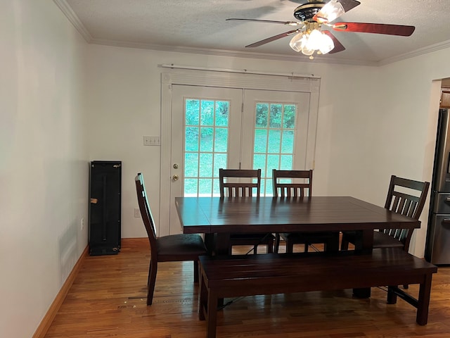 dining room with a textured ceiling, ceiling fan, and hardwood / wood-style flooring