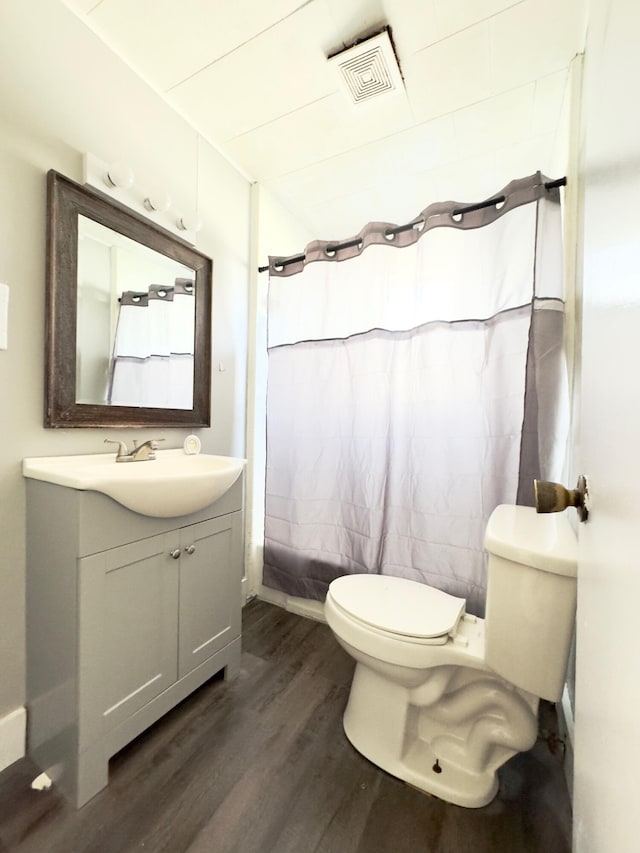 bathroom with vanity, toilet, and hardwood / wood-style flooring