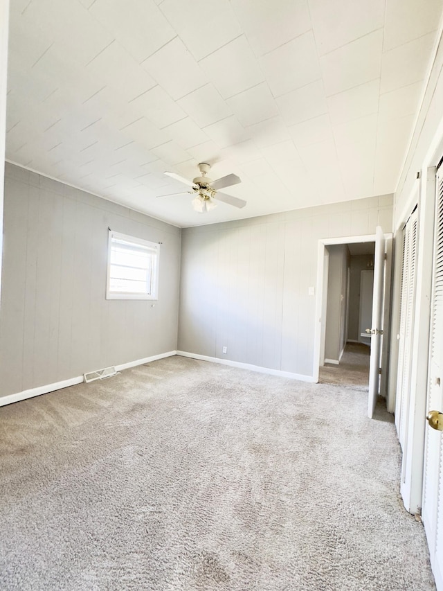 carpeted empty room featuring ceiling fan