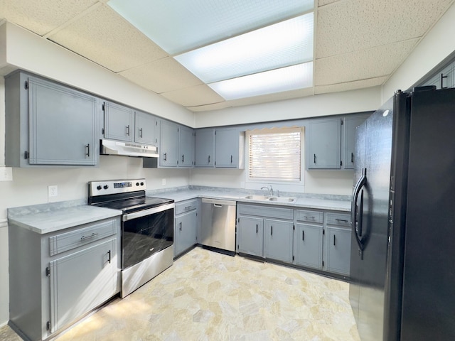 kitchen featuring a paneled ceiling, sink, gray cabinetry, and stainless steel appliances