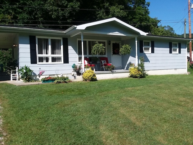 rear view of property featuring a porch and a lawn