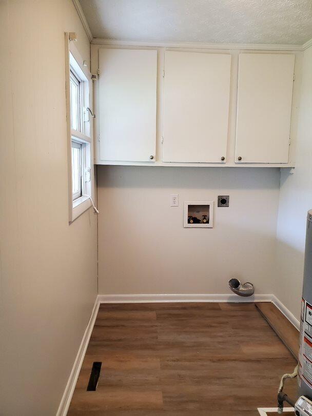 clothes washing area featuring dark hardwood / wood-style floors, water heater, cabinets, hookup for a washing machine, and electric dryer hookup