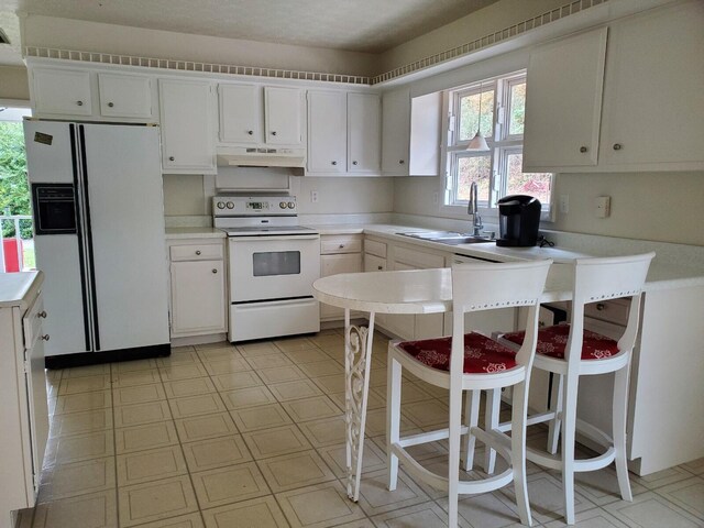 kitchen featuring white cabinetry, sink, and white appliances