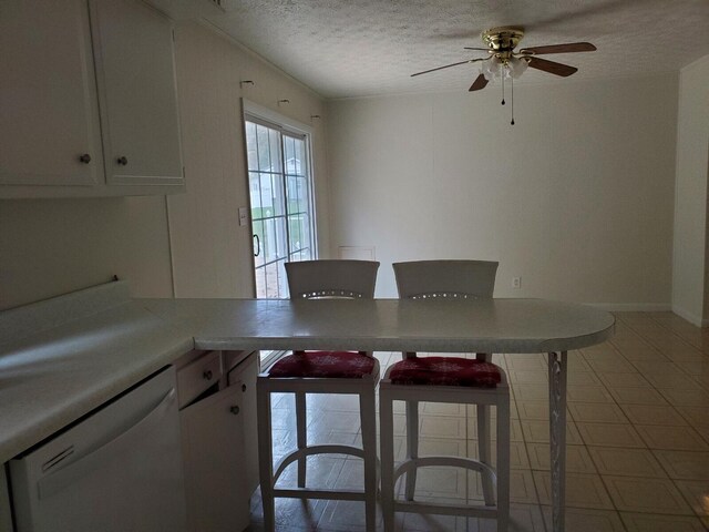 unfurnished dining area featuring ceiling fan and a textured ceiling