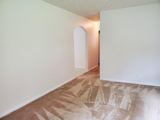 carpeted spare room featuring a textured ceiling