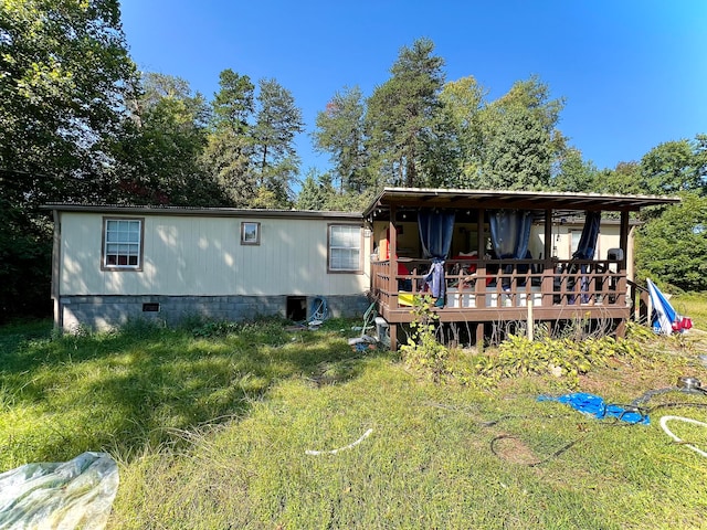 rear view of house featuring a wooden deck