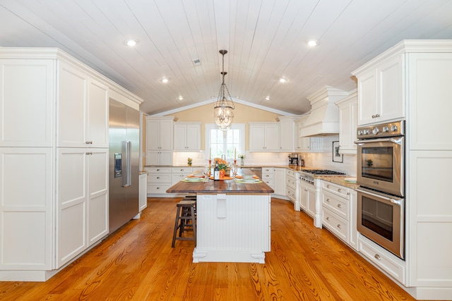 kitchen with white cabinetry, a center island, stainless steel appliances, and tasteful backsplash