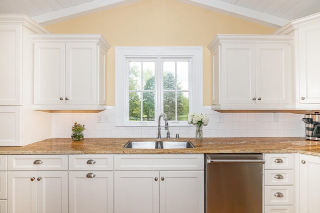 kitchen featuring vaulted ceiling, sink, and white cabinetry