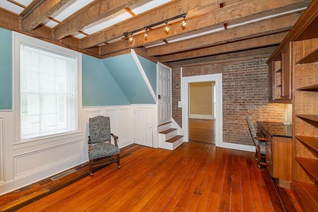 sitting room with dark hardwood / wood-style flooring and brick wall