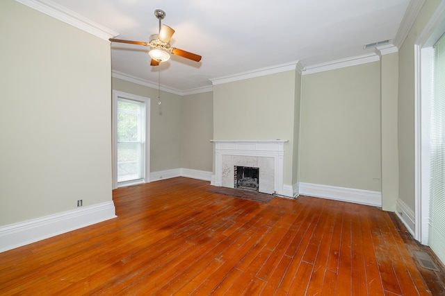 unfurnished living room featuring ceiling fan, crown molding, hardwood / wood-style flooring, and a brick fireplace