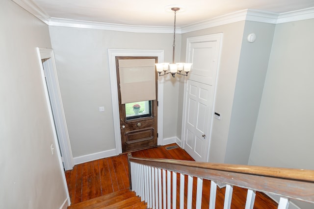 stairs with hardwood / wood-style flooring and ornamental molding