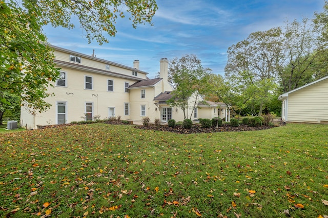 back of house with central AC and a yard