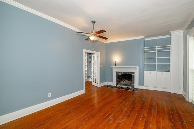 unfurnished living room with ceiling fan, ornamental molding, a fireplace, and wood-type flooring