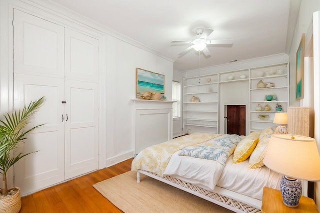 bedroom featuring ceiling fan, crown molding, and hardwood / wood-style floors