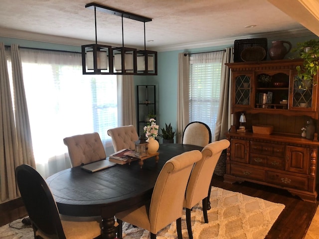 dining space with ornamental molding and wood finished floors