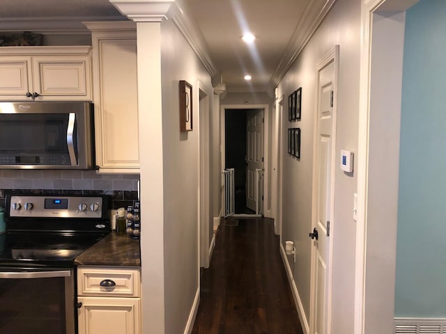 hall with baseboards, visible vents, dark wood-style floors, ornamental molding, and recessed lighting