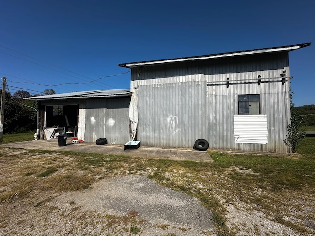 view of home's exterior with a pole building and an outbuilding