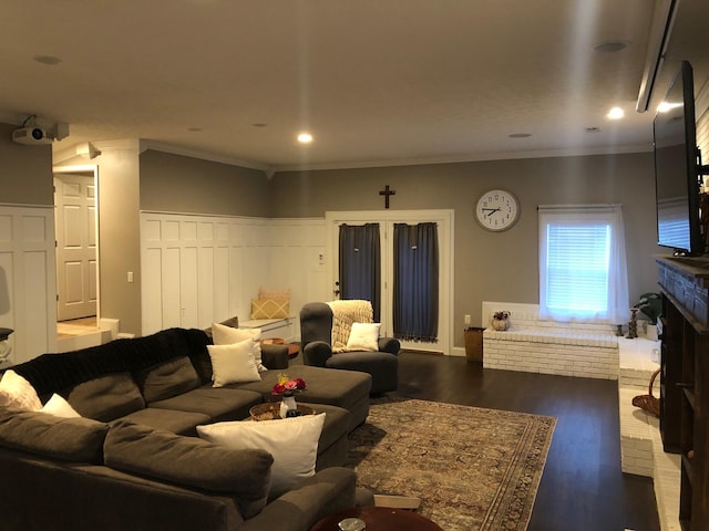 living area with a brick fireplace, crown molding, wood finished floors, and recessed lighting