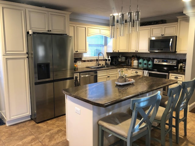 kitchen with stainless steel appliances, tasteful backsplash, dark countertops, and a sink