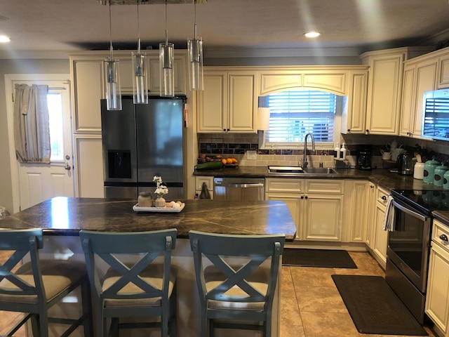 kitchen with dark countertops, appliances with stainless steel finishes, backsplash, and a sink