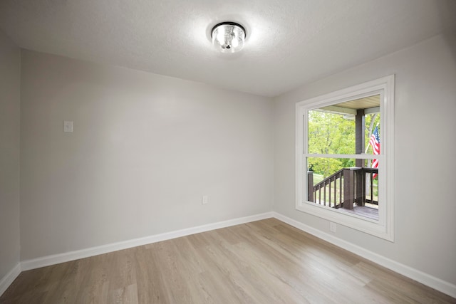 empty room with a textured ceiling and light wood-type flooring