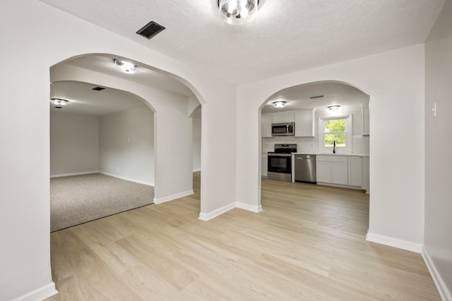 interior space with light hardwood / wood-style flooring, a textured ceiling, and sink