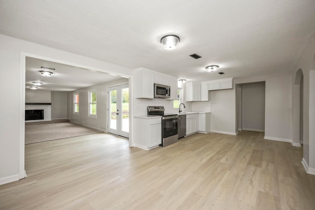 kitchen featuring appliances with stainless steel finishes, light hardwood / wood-style flooring, white cabinetry, and sink