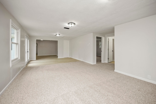 carpeted empty room featuring a textured ceiling