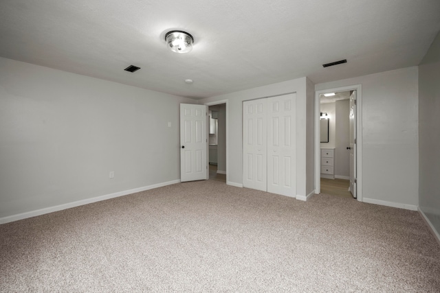 unfurnished bedroom featuring carpet floors and a closet