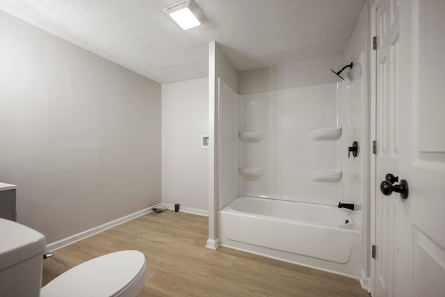 full bathroom with a textured ceiling, hardwood / wood-style flooring, toilet, vanity, and shower / bath combination