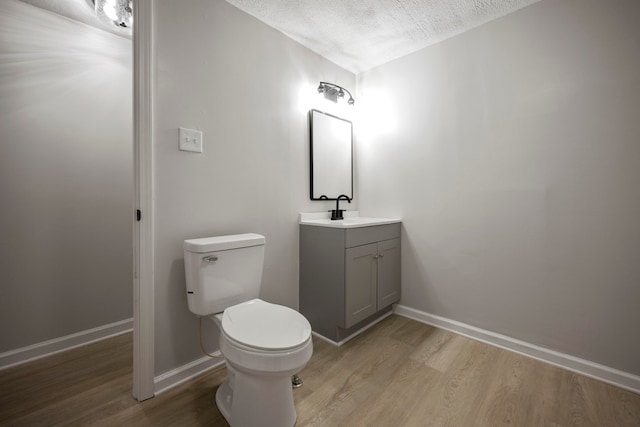 bathroom with vanity, hardwood / wood-style floors, a textured ceiling, and toilet