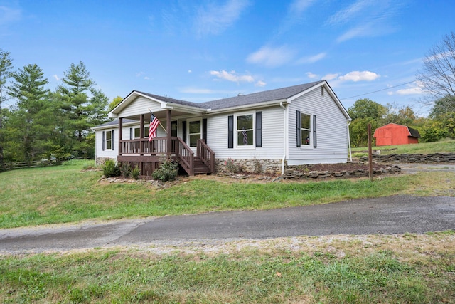 view of front of property featuring a front yard and a storage shed