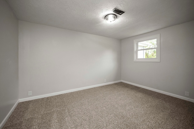 spare room with a textured ceiling and carpet