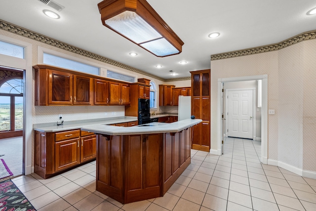 kitchen with a kitchen breakfast bar, black appliances, a kitchen island, and light tile patterned floors