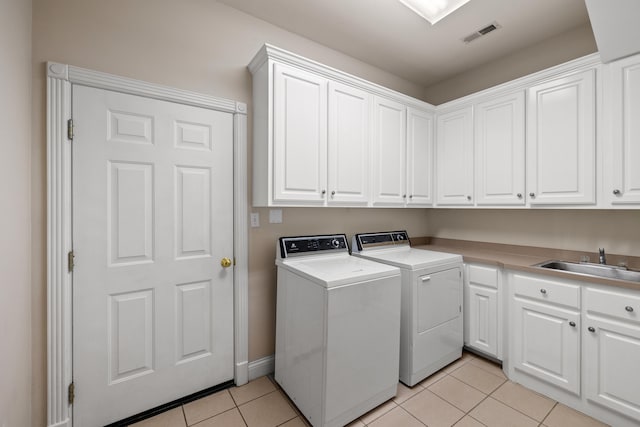 laundry area with cabinets, sink, independent washer and dryer, and light tile patterned flooring